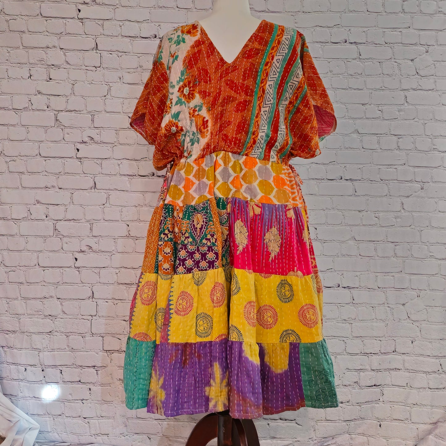Twillow Marigold Muse Kantha Midi Dress with orange, yellow, and pink patchwork panels featuring Kantha stitching and boho V-neck design.