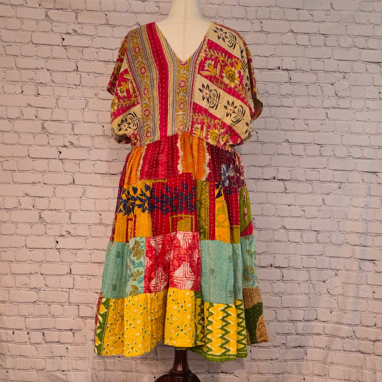 Twillow Sunfire Muse Kantha Midi Dress featuring floral yellow and pink bodice with multicolor patchwork skirt and Kantha stitching detail.