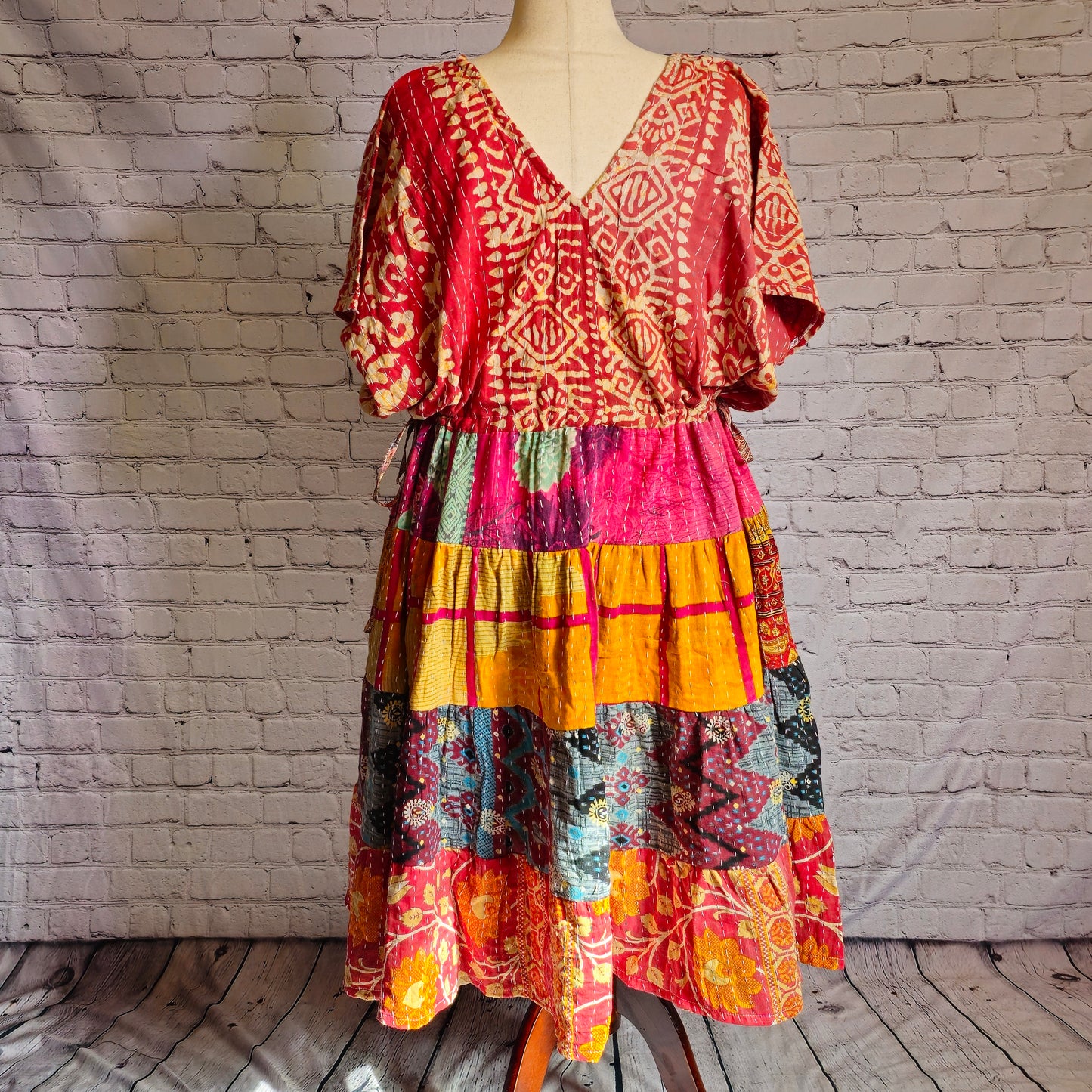 Twillow Ember Muse Kantha Midi Dress featuring a red and gold patterned bodice with magenta, teal, and saffron patchwork skirt accented by Kantha stitching.