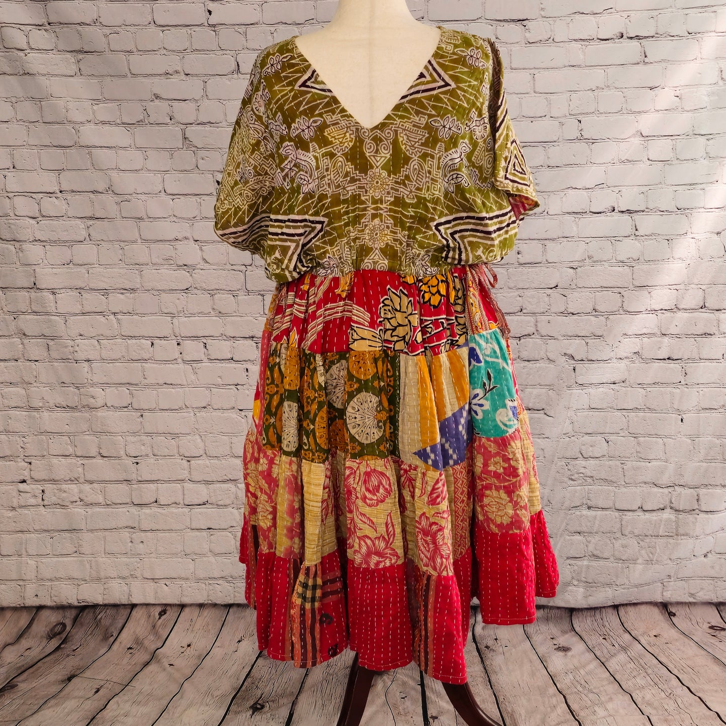 Twillow Nomad Bloom Kantha Midi Dress with olive geometric bodice and red, yellow, and blue patchwork skirt featuring Kantha stitching details.