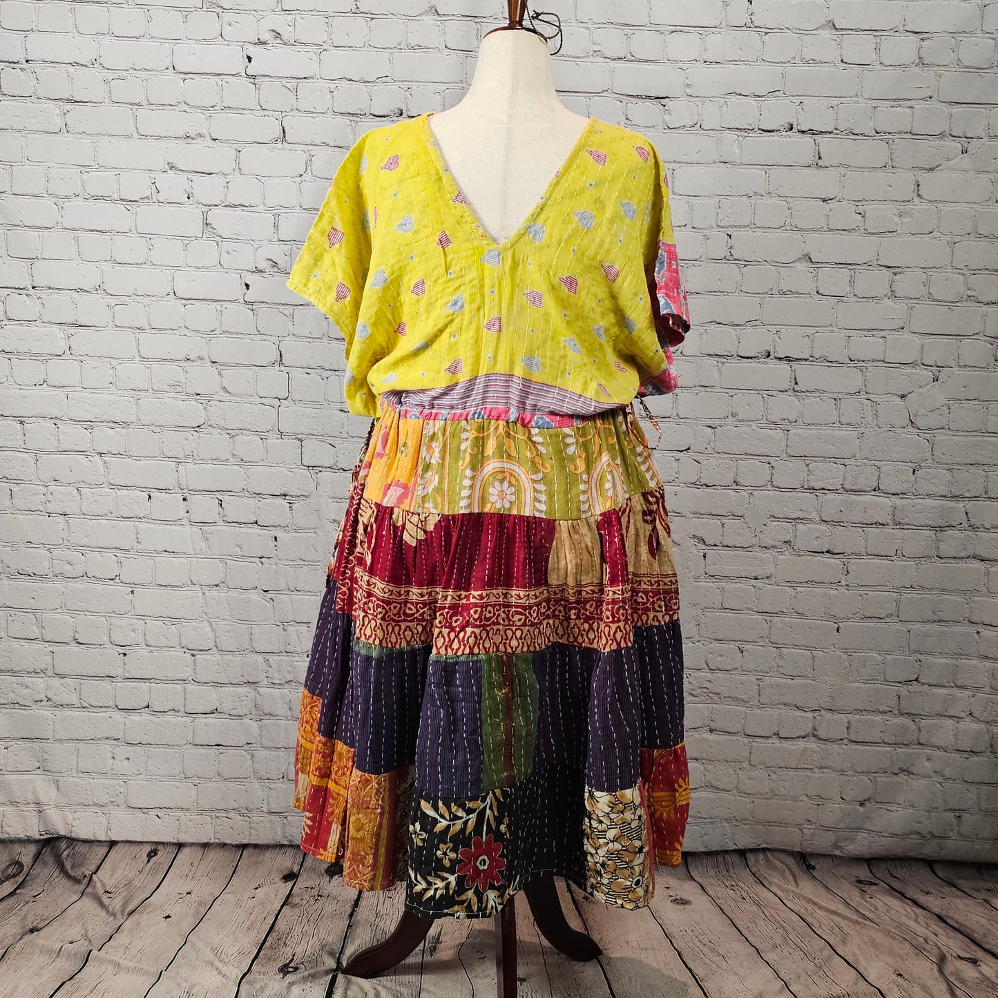 Bright citrus-colored Twillow Kantha Midi Dress with a yellow bodice and multicolor orange, plum, teal, and gold patchwork skirt featuring visible Kantha stitching.
