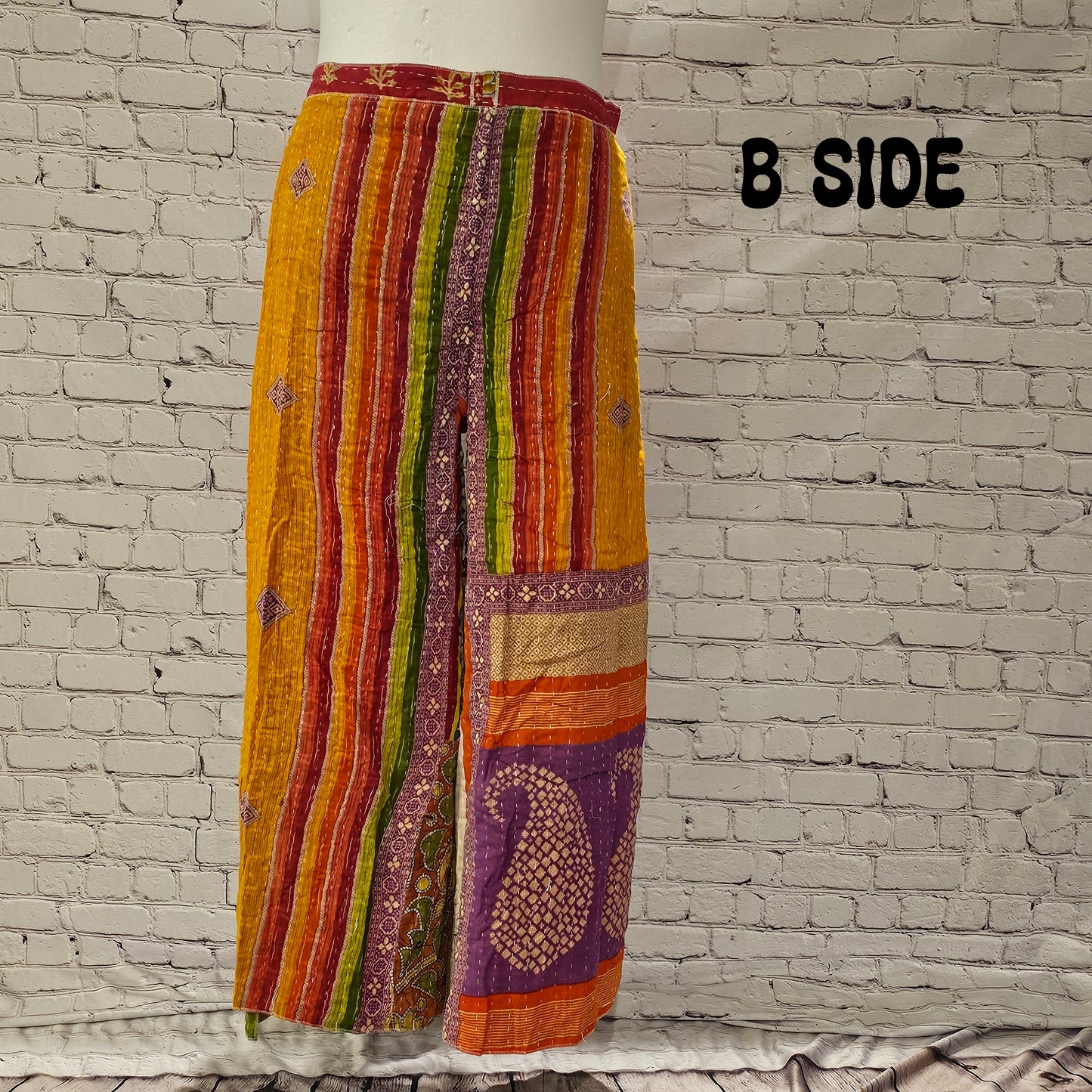 Front view of Ronin Kantha unisex wrap pants, made from recycled sari fabric in boho patchwork design.