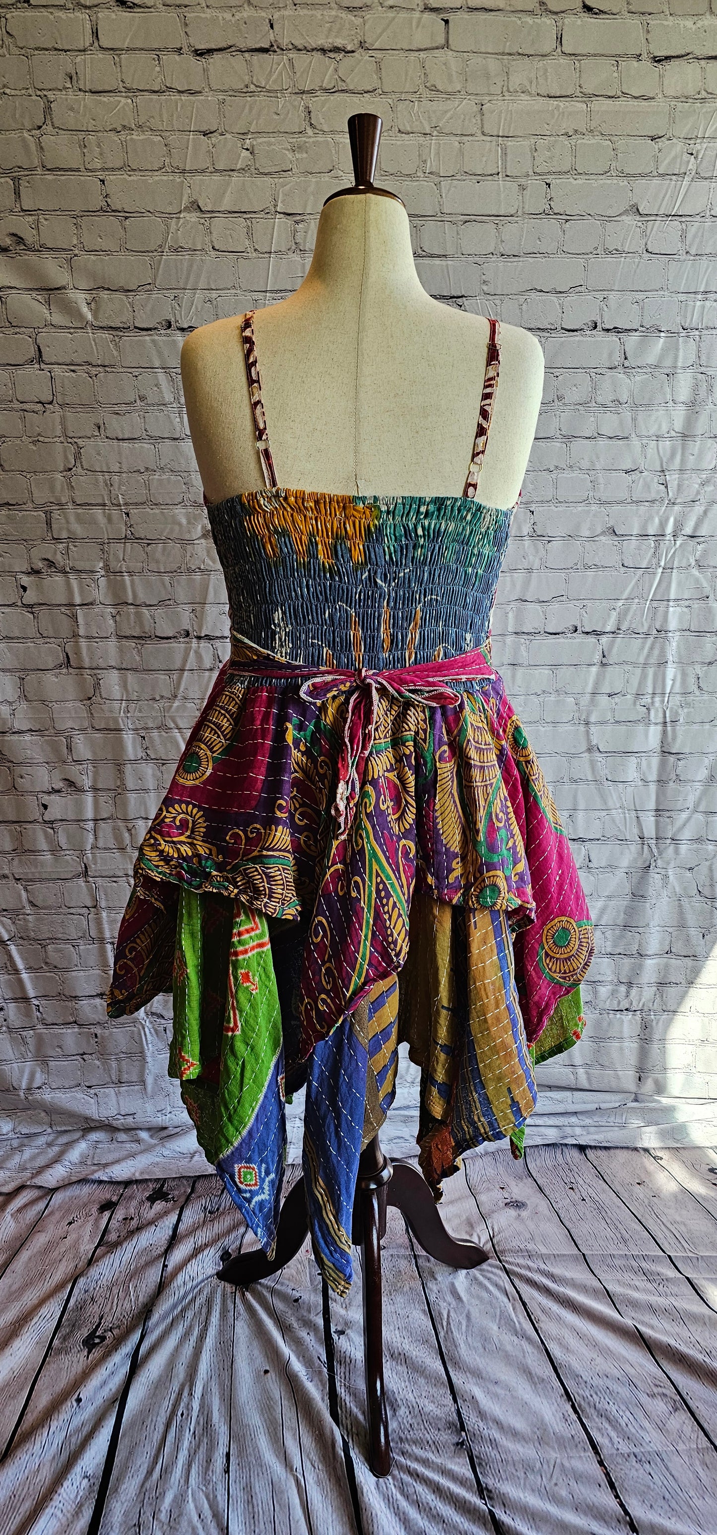 Back-facing image of Krysta boho Kantha dress, recycled sari fabric with tiered skirt flow.