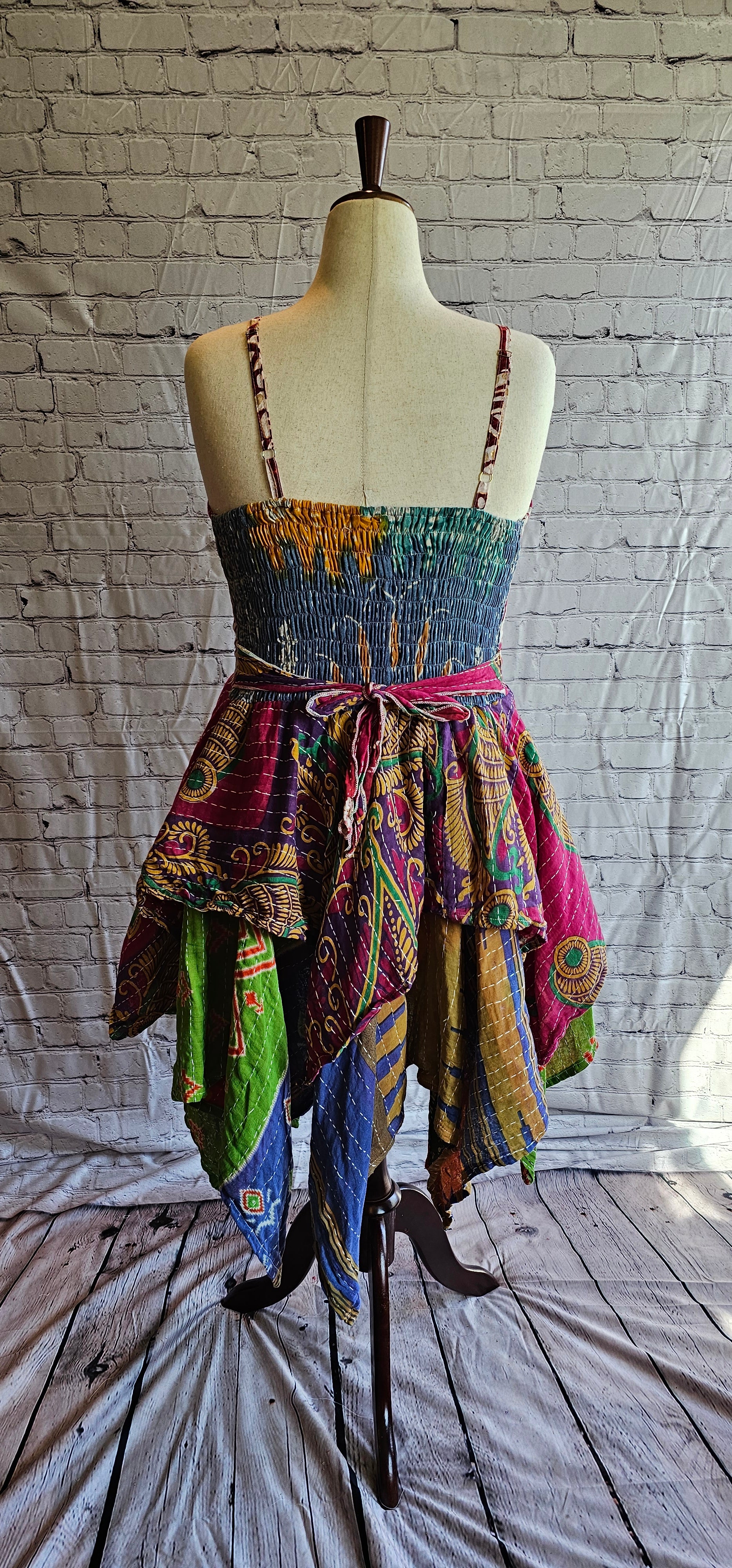 Back-facing image of Krysta boho Kantha dress, recycled sari fabric with tiered skirt flow.