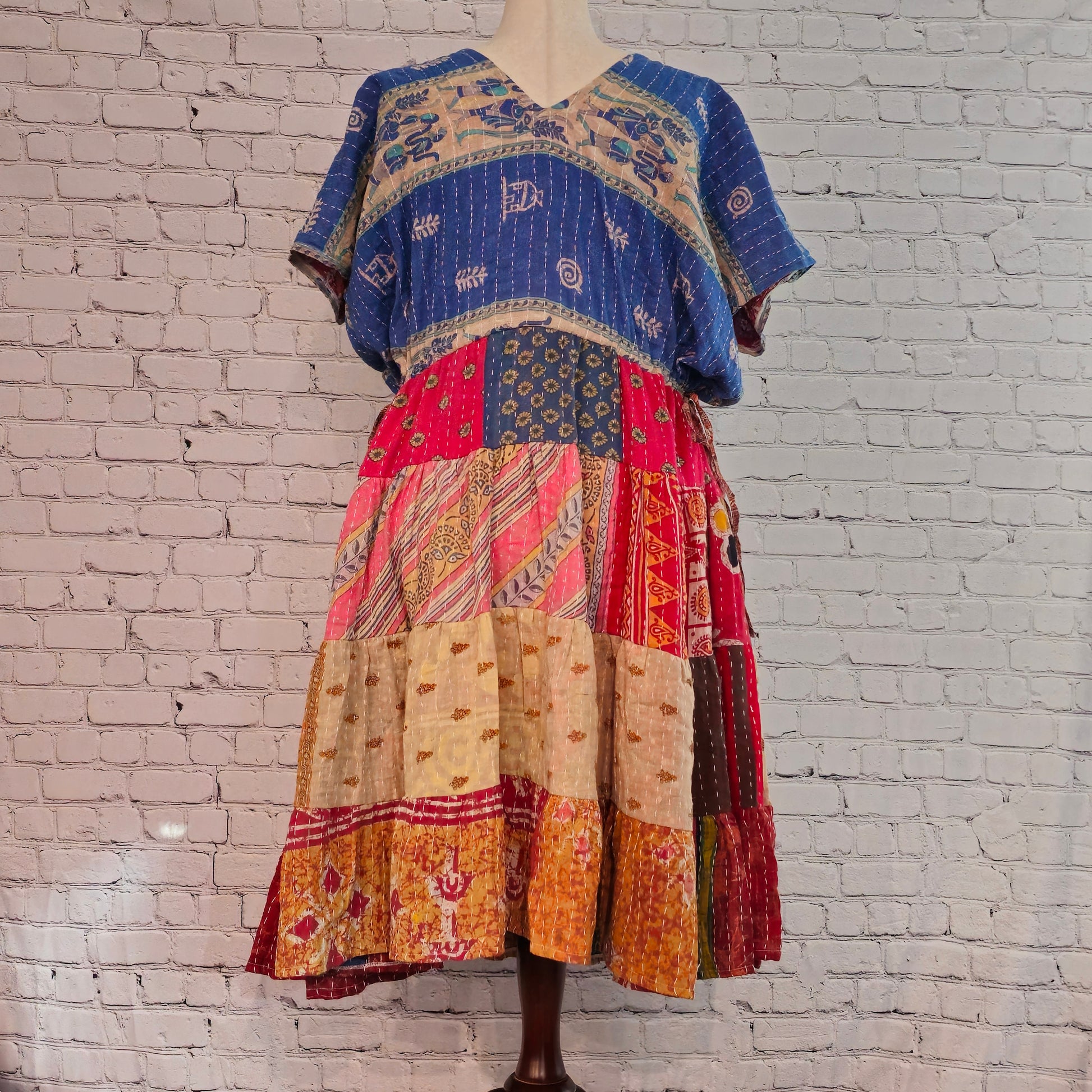 Twillow Indigo Dawn Kantha Midi Dress featuring a blue patterned bodice and colorful patchwork skirt with Kantha stitching detail.