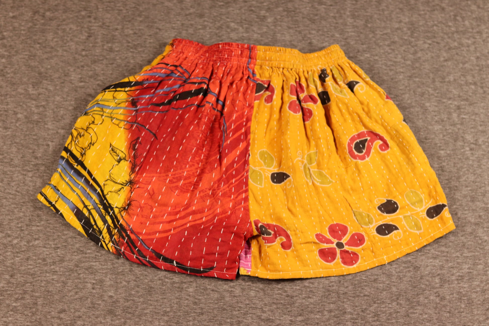 Unisex Kantha shorts with red and yellow cotton panels, detailed with Kantha stitching and a drawstring waist.”