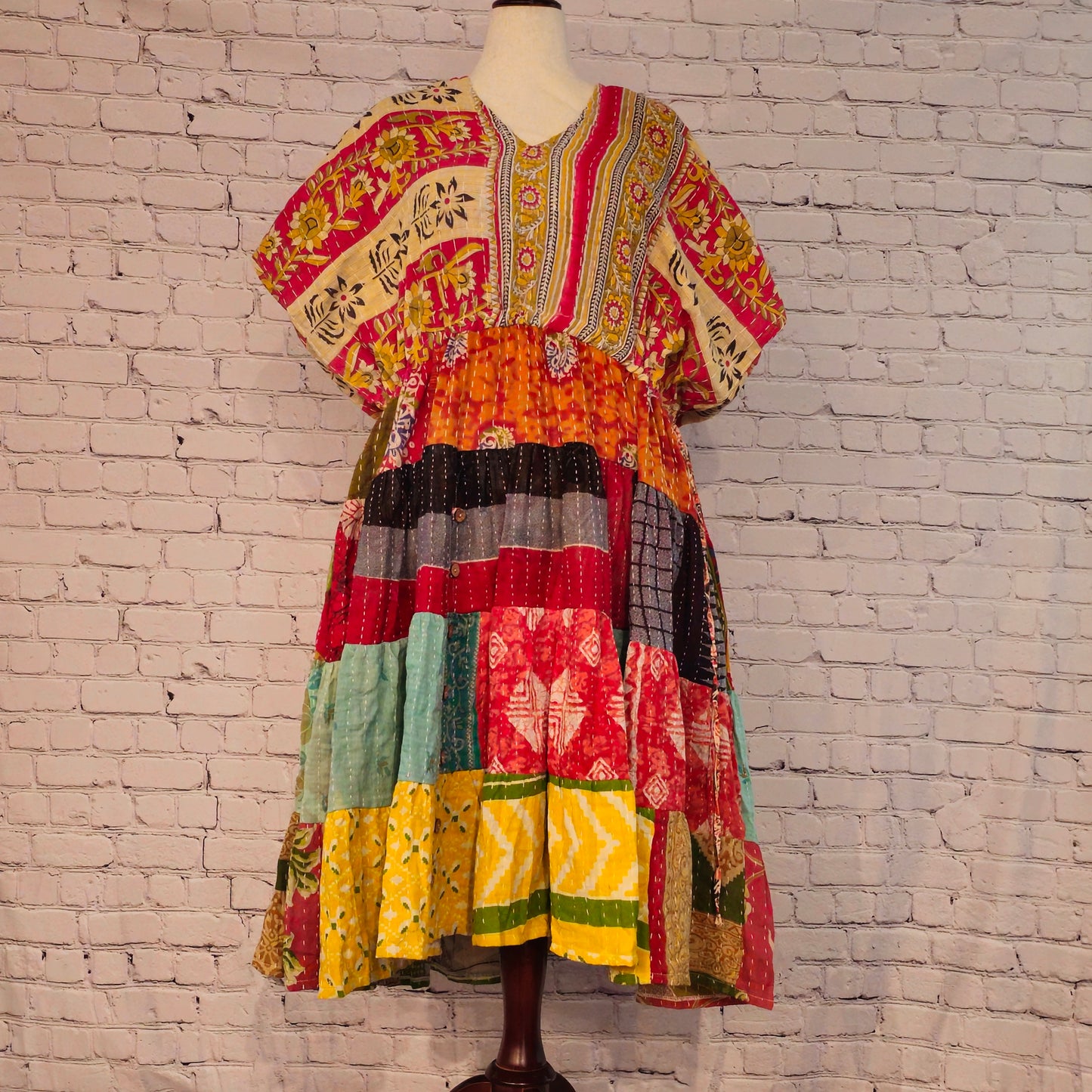 Twillow Sunfire Muse Kantha Midi Dress featuring floral yellow and pink bodice with multicolor patchwork skirt and Kantha stitching detail.
