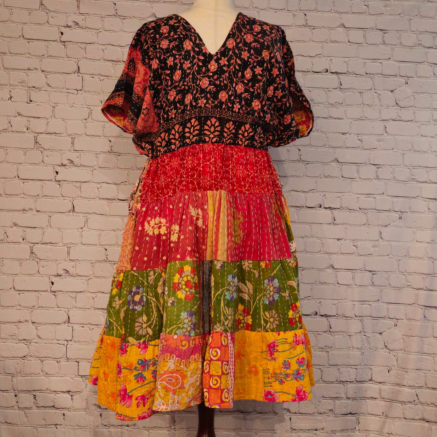 Twillow Wild Garden Kantha Midi Dress featuring a black floral bodice and multicolor floral patchwork skirt with Kantha stitching detail.