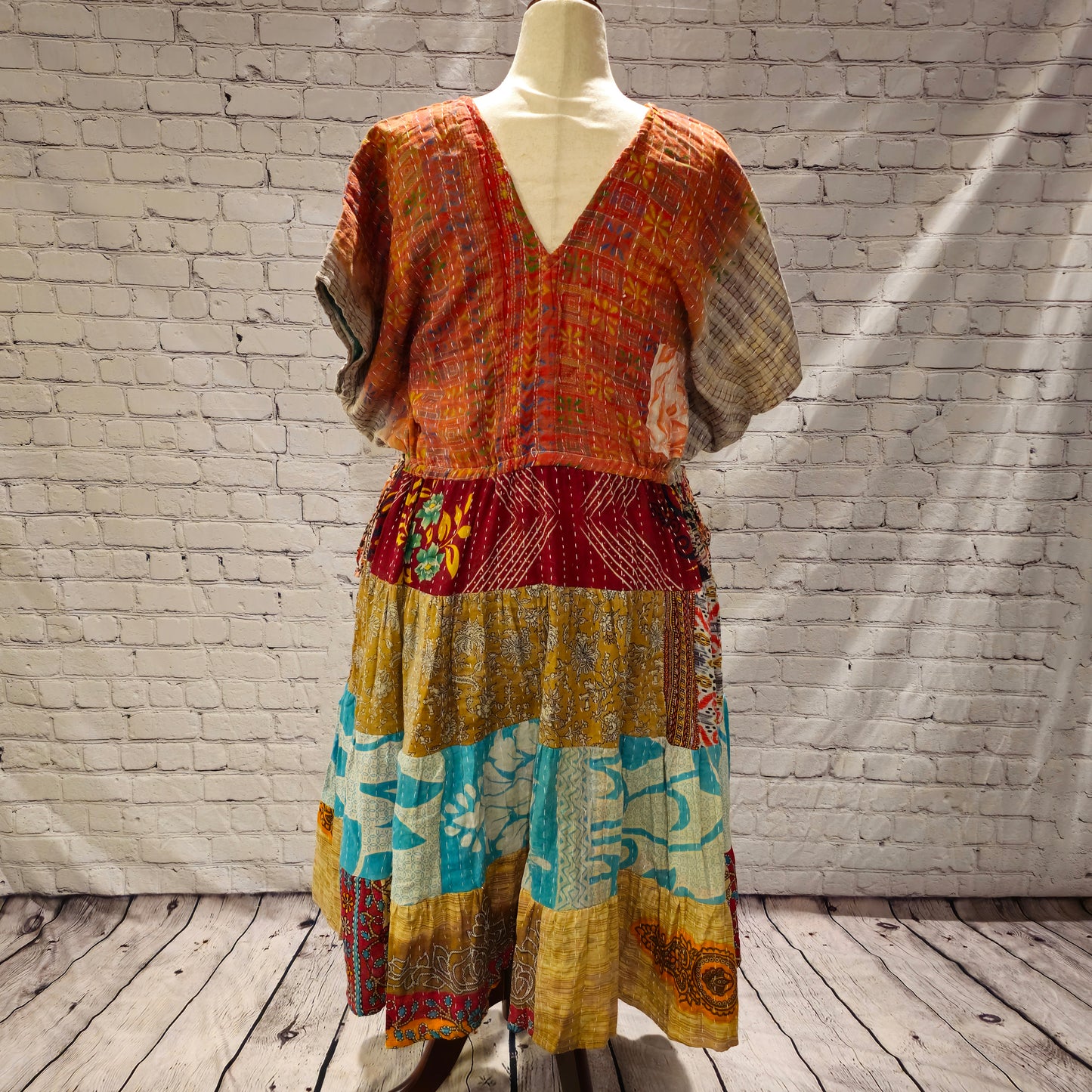 Twillow Amber Tide Kantha Midi Dress featuring an amber-toned bodice and gold, turquoise, and pink patchwork skirt with Kantha stitching.