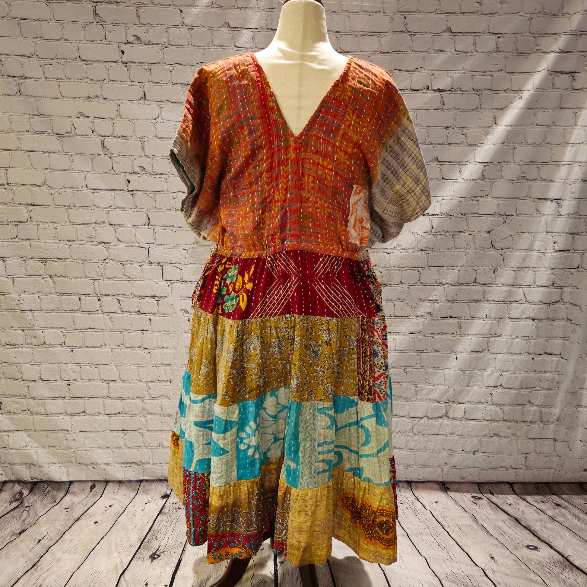 Twillow Amber Tide Kantha Midi Dress featuring an amber-toned bodice and gold, turquoise, and pink patchwork skirt with Kantha stitching.