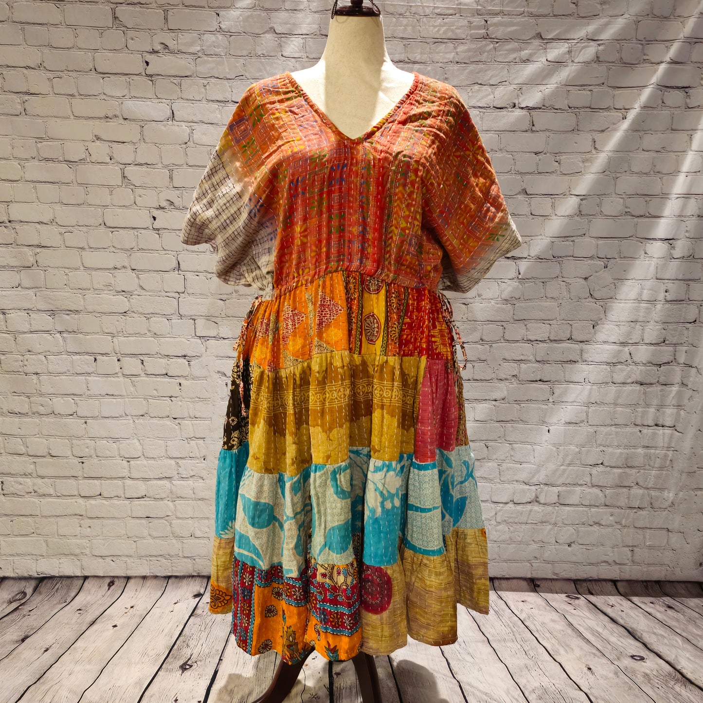 Twillow Amber Tide Kantha Midi Dress featuring an amber-toned bodice and gold, turquoise, and pink patchwork skirt with Kantha stitching.