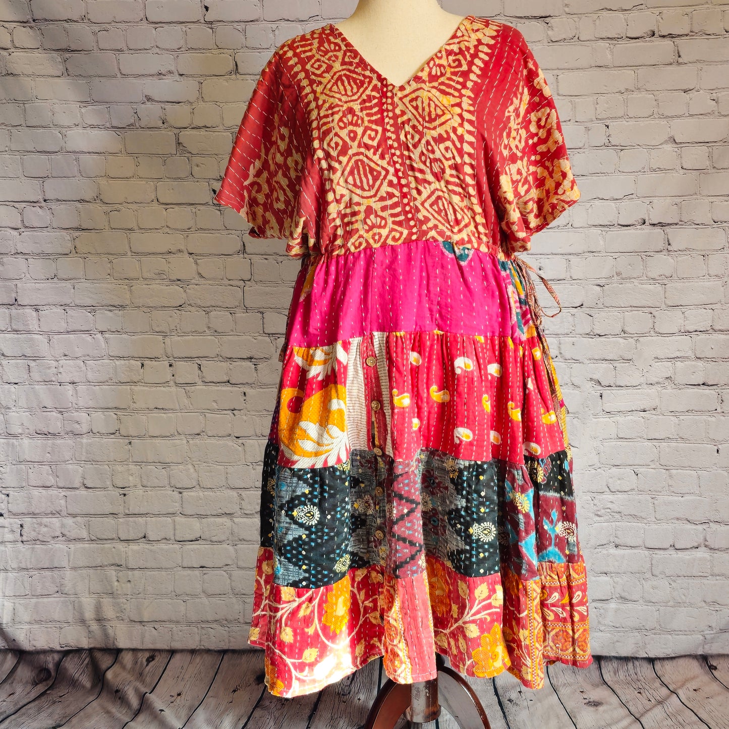 Twillow Ember Muse Kantha Midi Dress featuring a red and gold patterned bodice with magenta, teal, and saffron patchwork skirt accented by Kantha stitching.