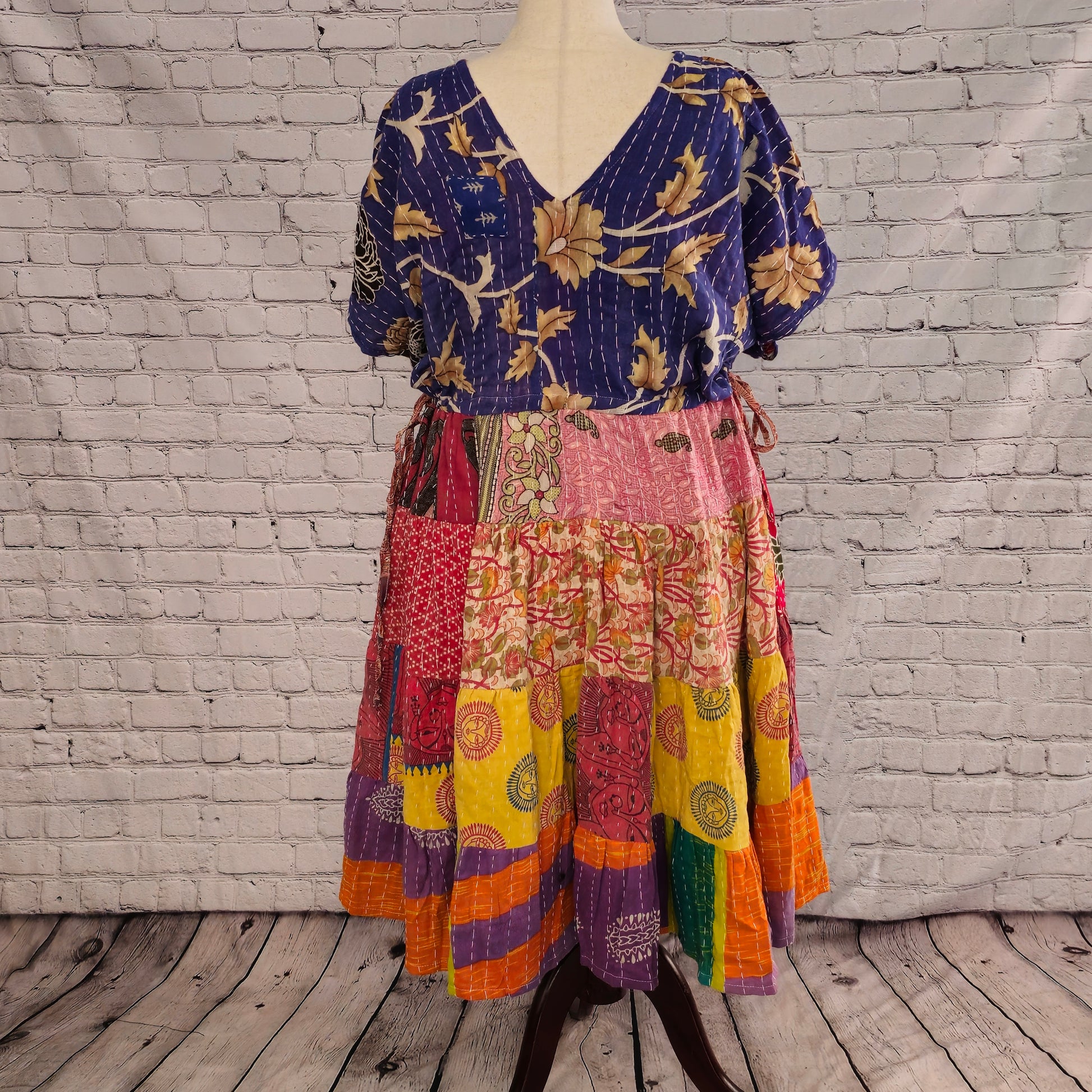Twillow Festival Bloom Kantha Midi Dress featuring a deep indigo floral bodice and colorful patchwork skirt in pink, teal, yellow, and orange with Kantha stitching.