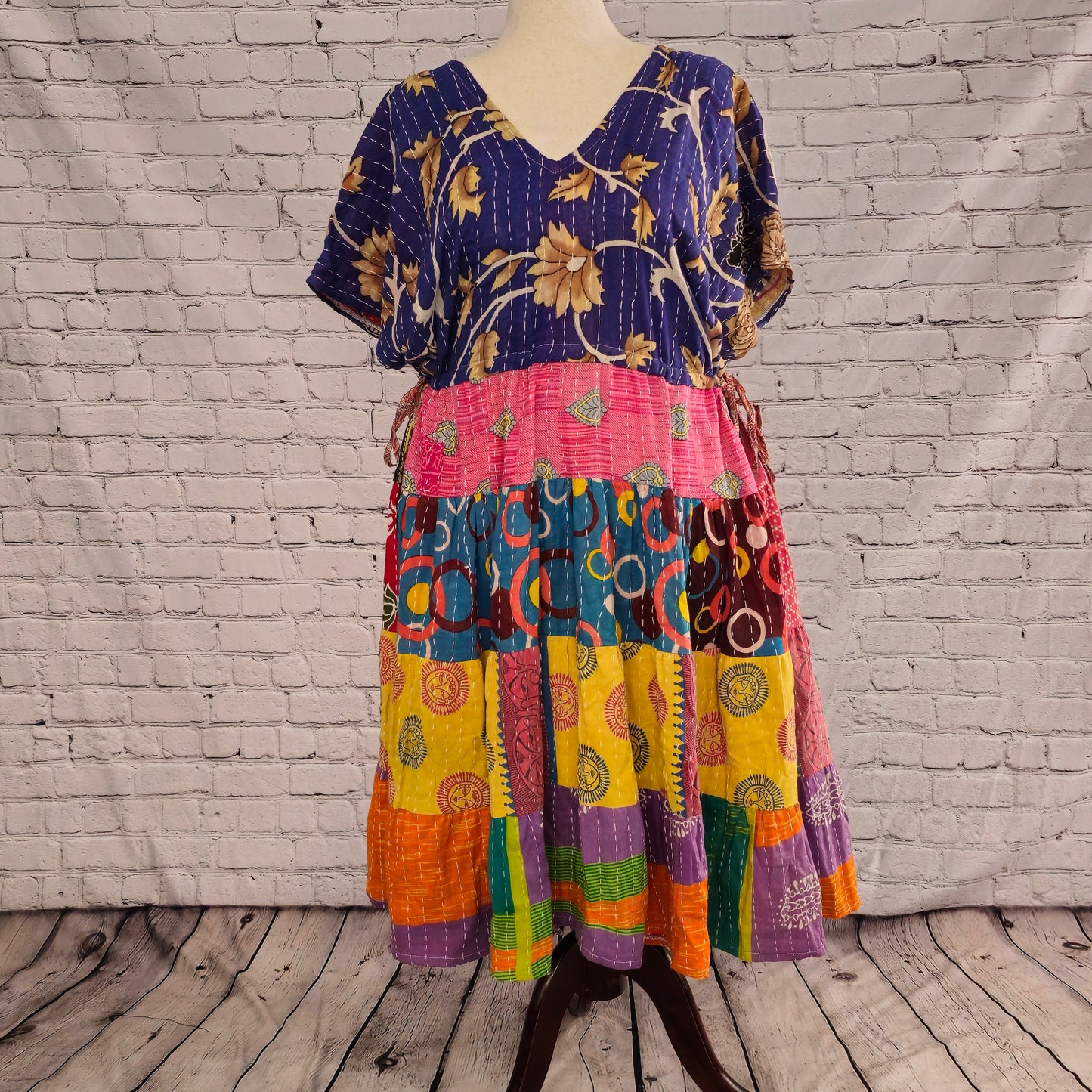 Twillow Festival Bloom Kantha Midi Dress featuring a deep indigo floral bodice and colorful patchwork skirt in pink, teal, yellow, and orange with Kantha stitching.