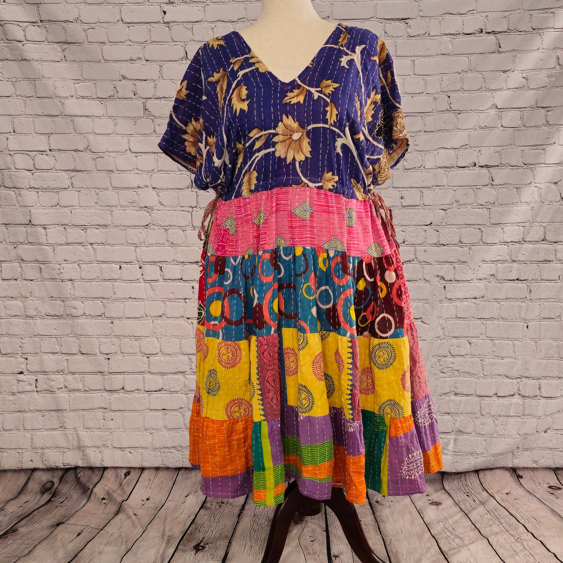 Twillow Festival Bloom Kantha Midi Dress featuring a deep indigo floral bodice and colorful patchwork skirt in pink, teal, yellow, and orange with Kantha stitching.