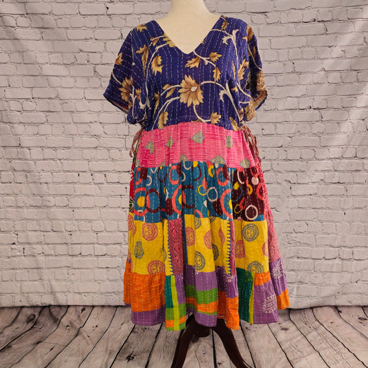 Twillow Festival Bloom Kantha Midi Dress featuring a deep indigo floral bodice and colorful patchwork skirt in pink, teal, yellow, and orange with Kantha stitching.