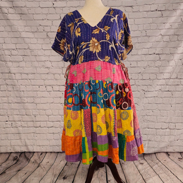 Twillow Festival Bloom Kantha Midi Dress featuring a deep indigo floral bodice and colorful patchwork skirt in pink, teal, yellow, and orange with Kantha stitching.