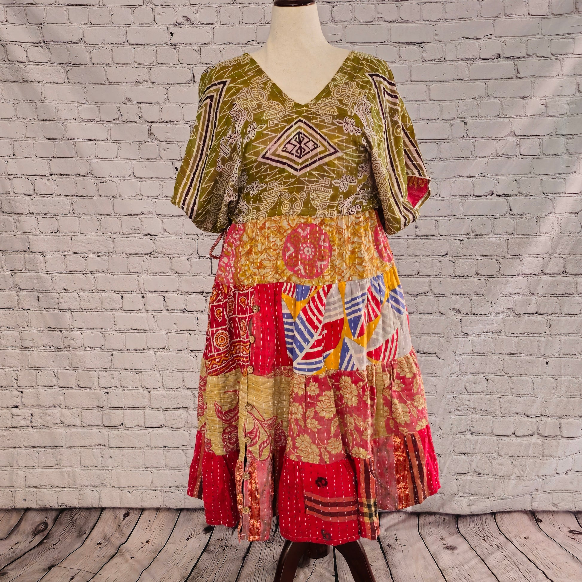 Twillow Nomad Bloom Kantha Midi Dress with olive geometric bodice and red, yellow, and blue patchwork skirt featuring Kantha stitching details.