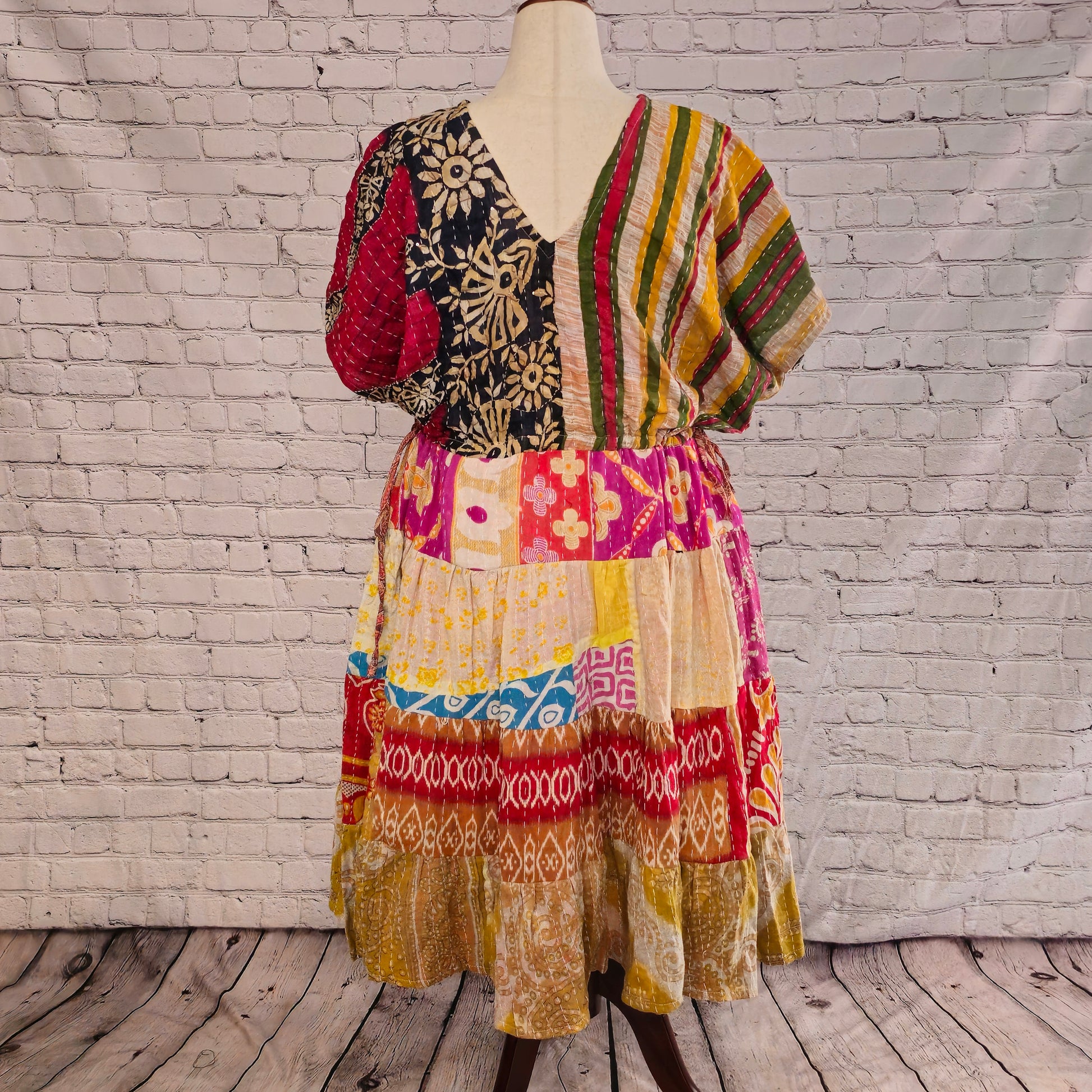 Twillow Spice Trail Kantha Midi Dress with striped and floral bodice and saffron, red, and tan patchwork skirt featuring Kantha stitching detail.