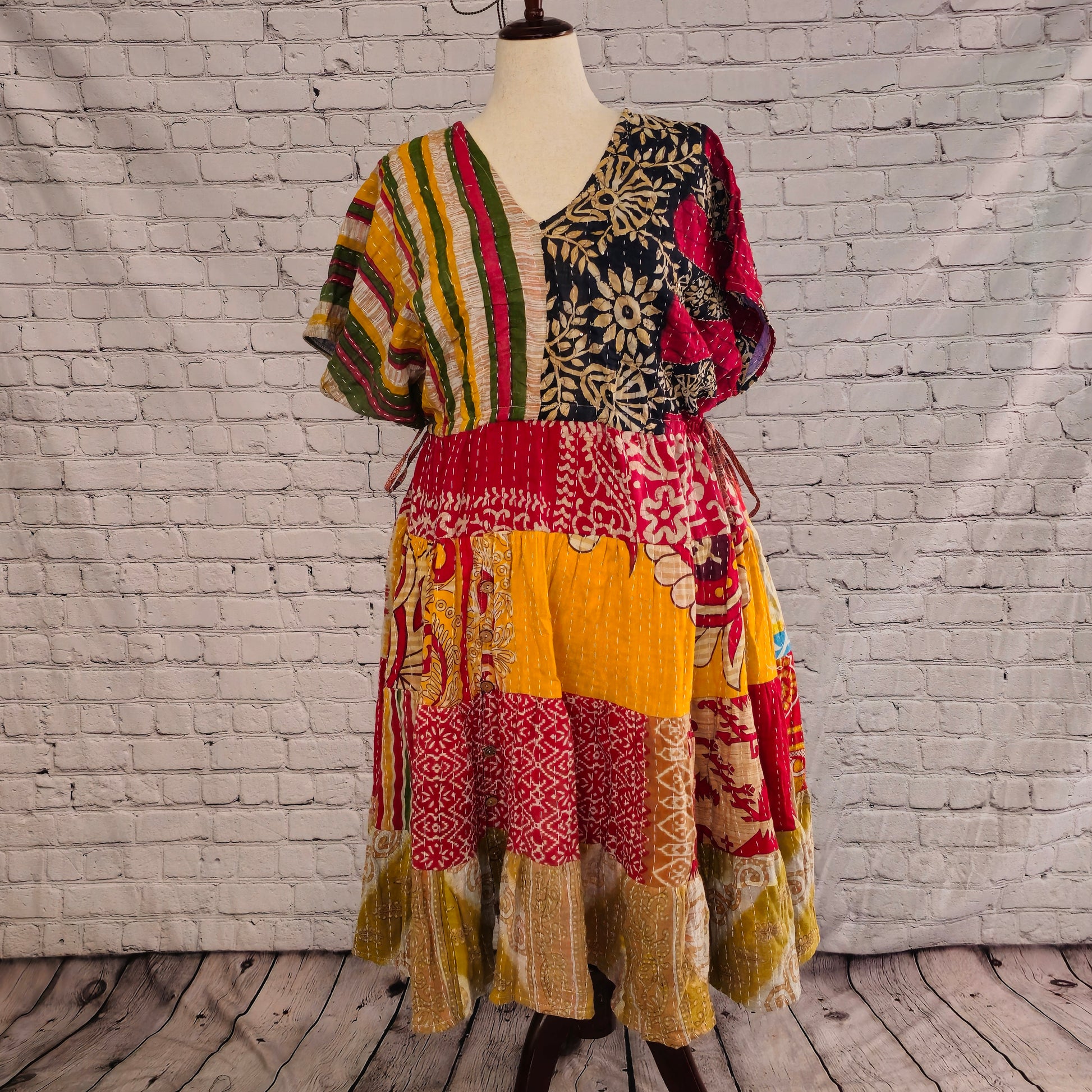 Twillow Spice Trail Kantha Midi Dress with striped and floral bodice and saffron, red, and tan patchwork skirt featuring Kantha stitching detail.