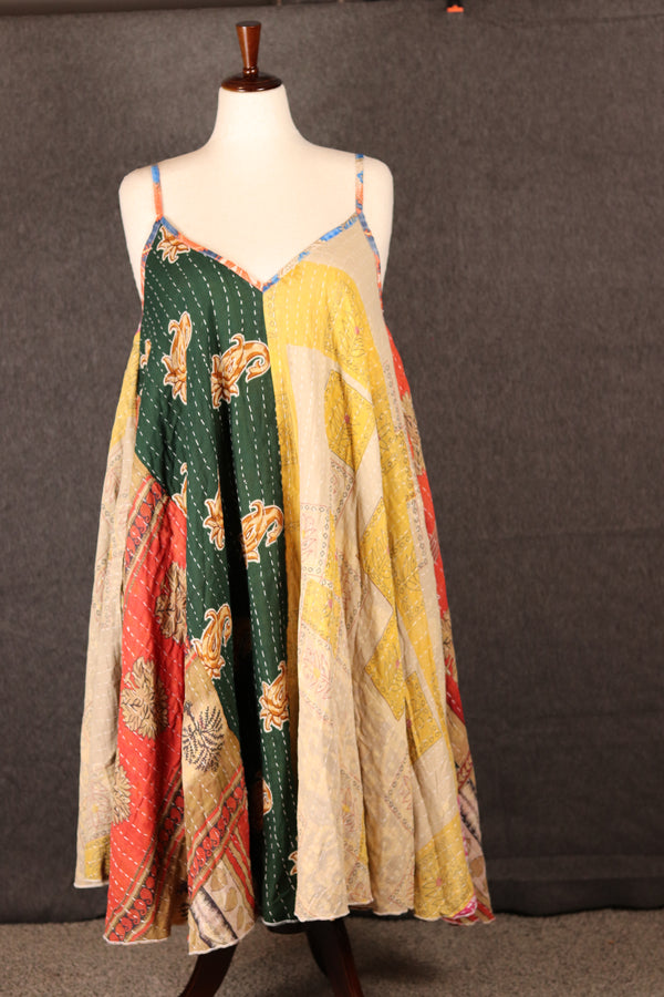 Front-facing image of Sora Kantha patchwork dress on mannequin, recycled sari fabric with hand-stitched Kantha embroidery.
