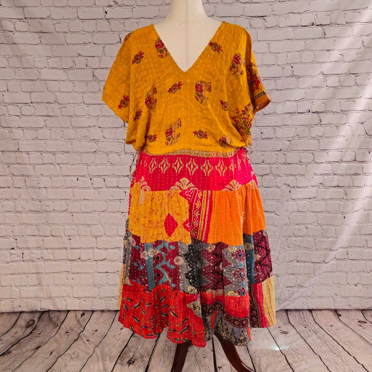 Twillow Desert Marigold Kantha Midi Dress featuring a golden yellow bodice and colorful red, teal, and black patchwork skirt with Kantha stitching detail.