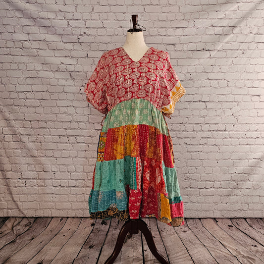 Twillow Sun Mirage Kantha Midi Dress featuring a red patterned top and a colorful patchwork skirt with aqua, coral, and golden tones accented by Kantha stitching.