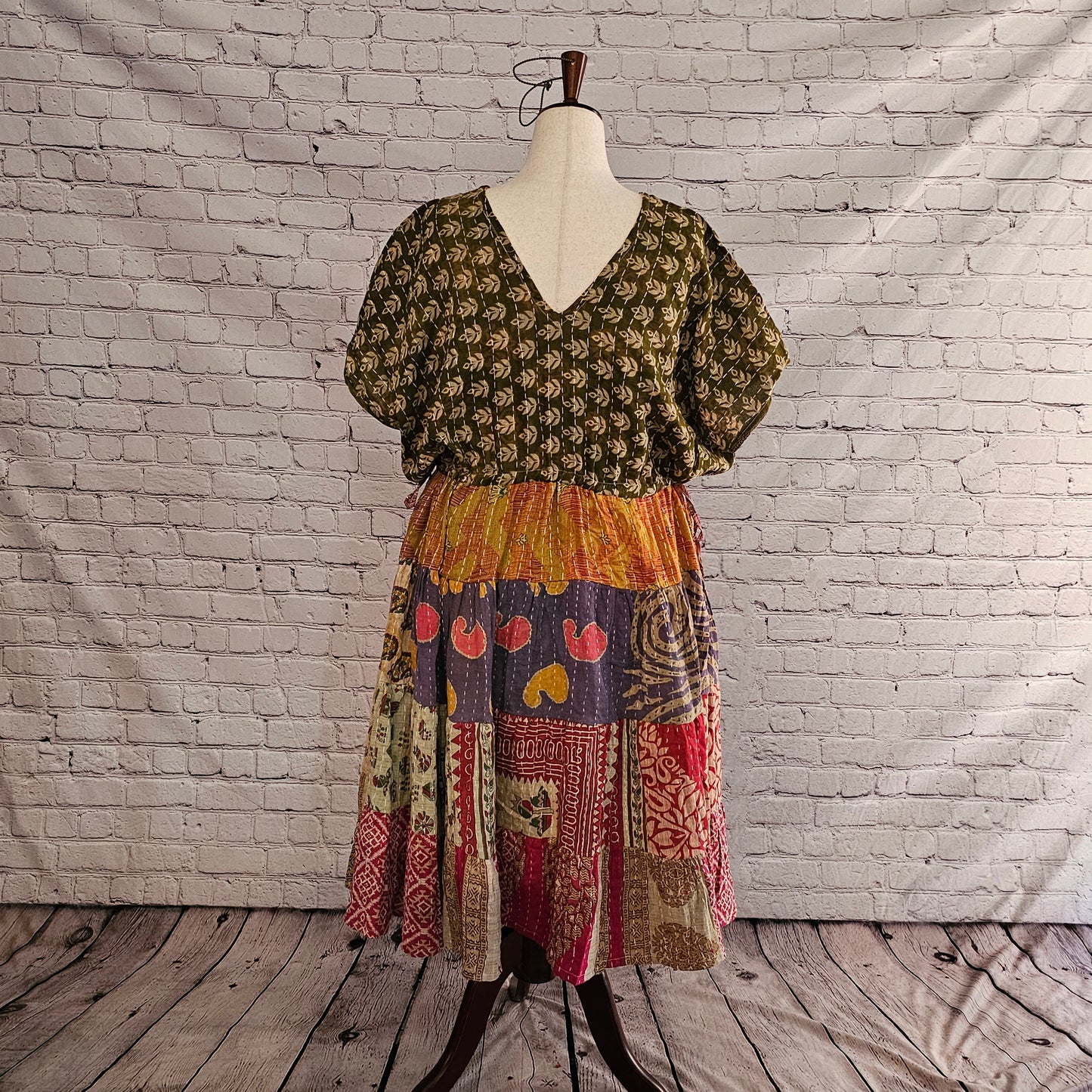 Twillow Forest Whimsy Kantha Midi Dress featuring an olive leaf-print top and a multi-color patchwork skirt in plum, sage, red, and gold accented by Kantha stitching.