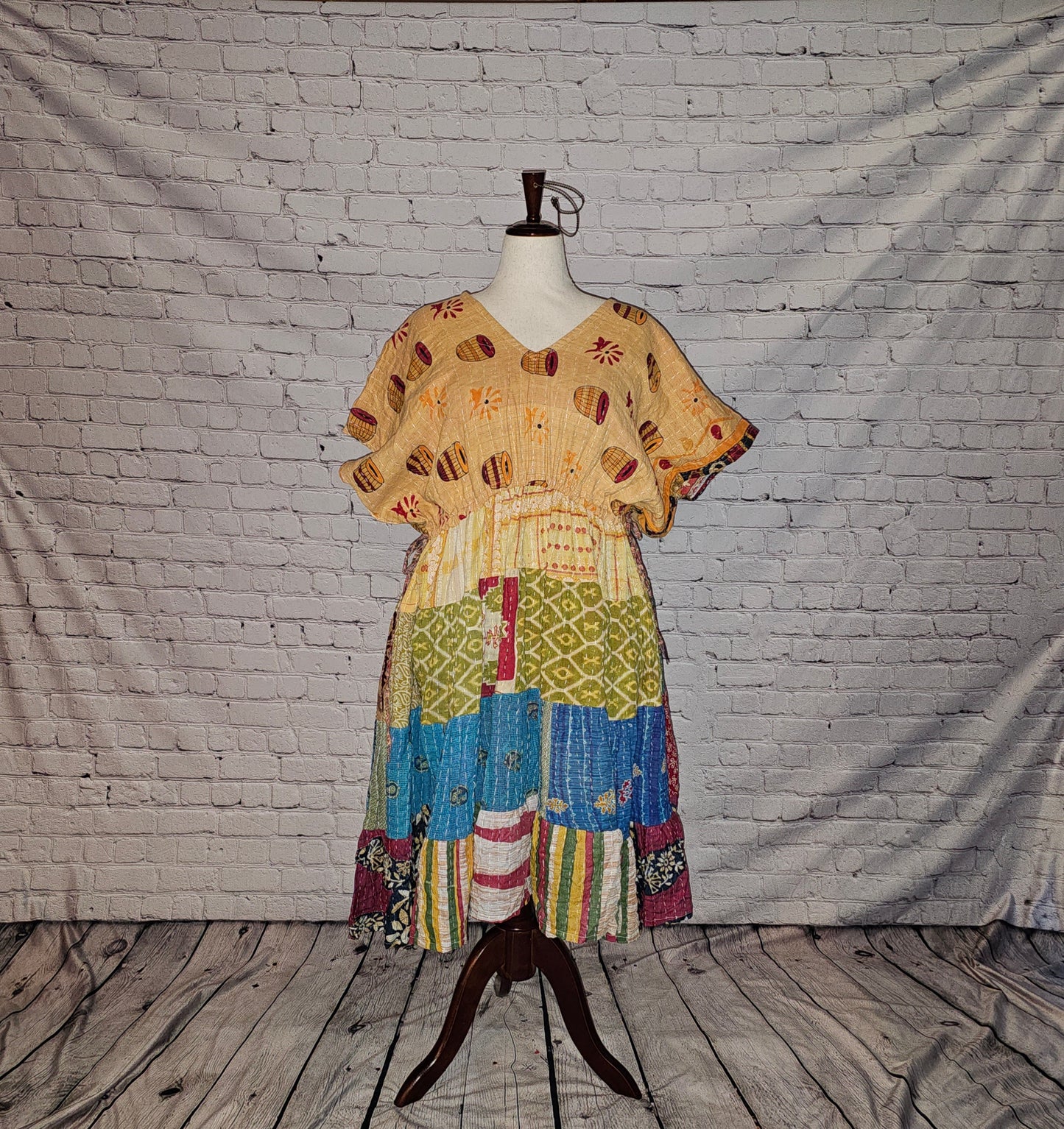 Twillow Sunlit Bazaar Kantha Midi Dress with a sandy gold patterned top and a colorful blue, green, and multicolor patchwork skirt enhanced by Kantha stitching.