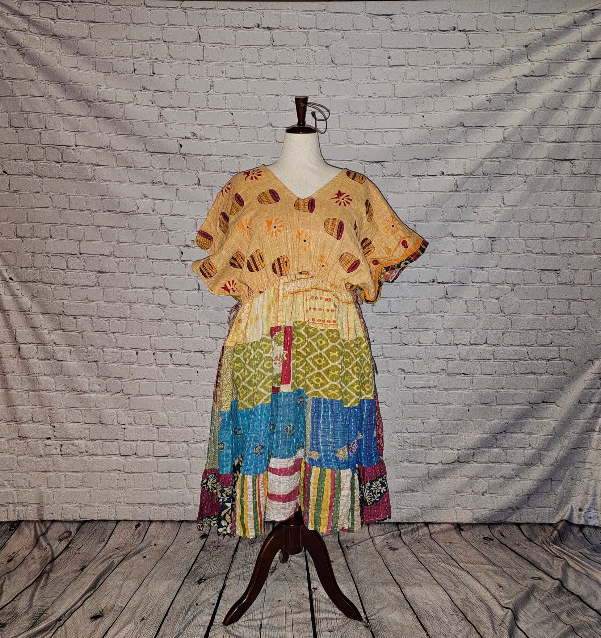 Twillow Sunlit Bazaar Kantha Midi Dress with a sandy gold patterned top and a colorful blue, green, and multicolor patchwork skirt enhanced by Kantha stitching.