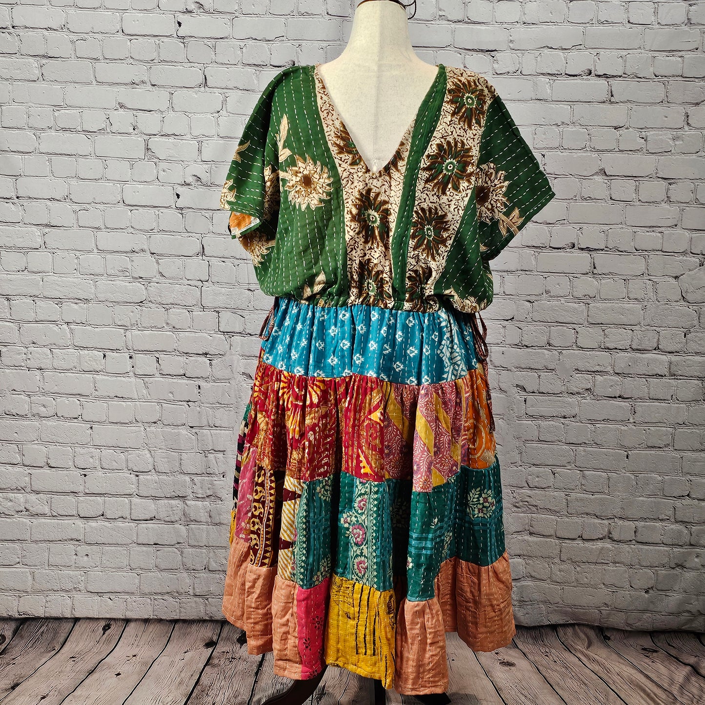 Twillow Forest Muse Kantha Midi Dress with green floral bodice and multicolor blue, teal, red, and peach patchwork skirt detailed with Kantha stitching.