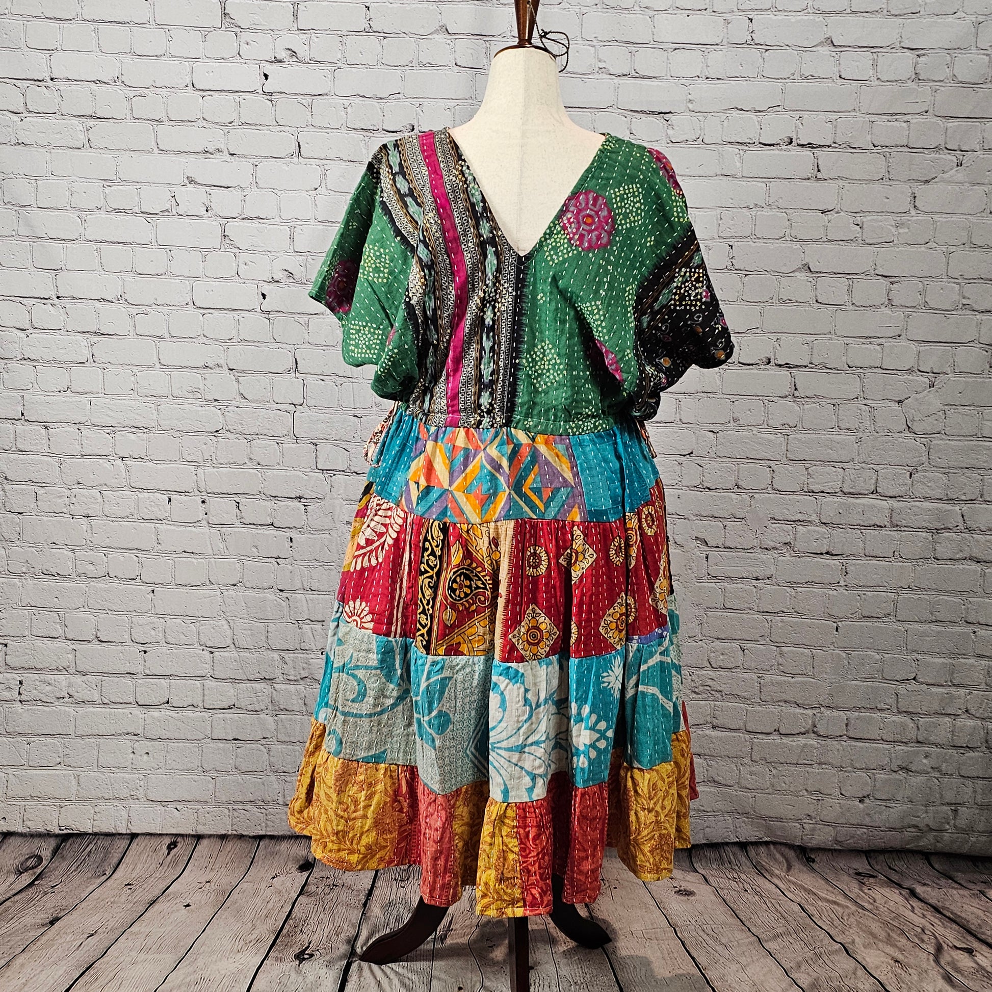 Green and magenta Twillow Emerald Sunburst Kantha Midi Dress with colorful yellow, teal, and red patchwork skirt and visible Kantha stitching.