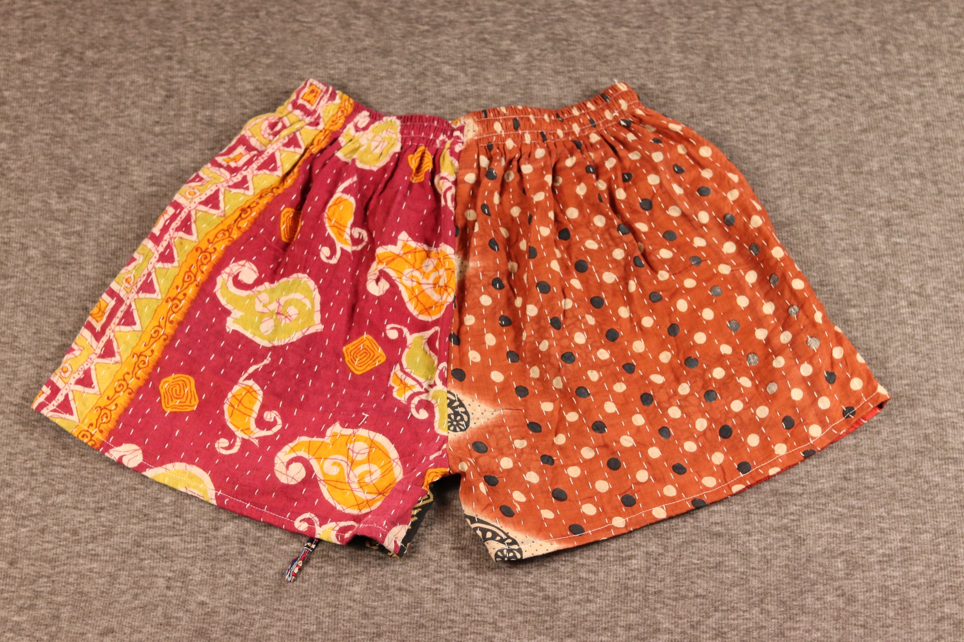 “Unisex Kantha shorts in red, orange, and black cotton, detailed with Kantha stitching and drawstring waist.”