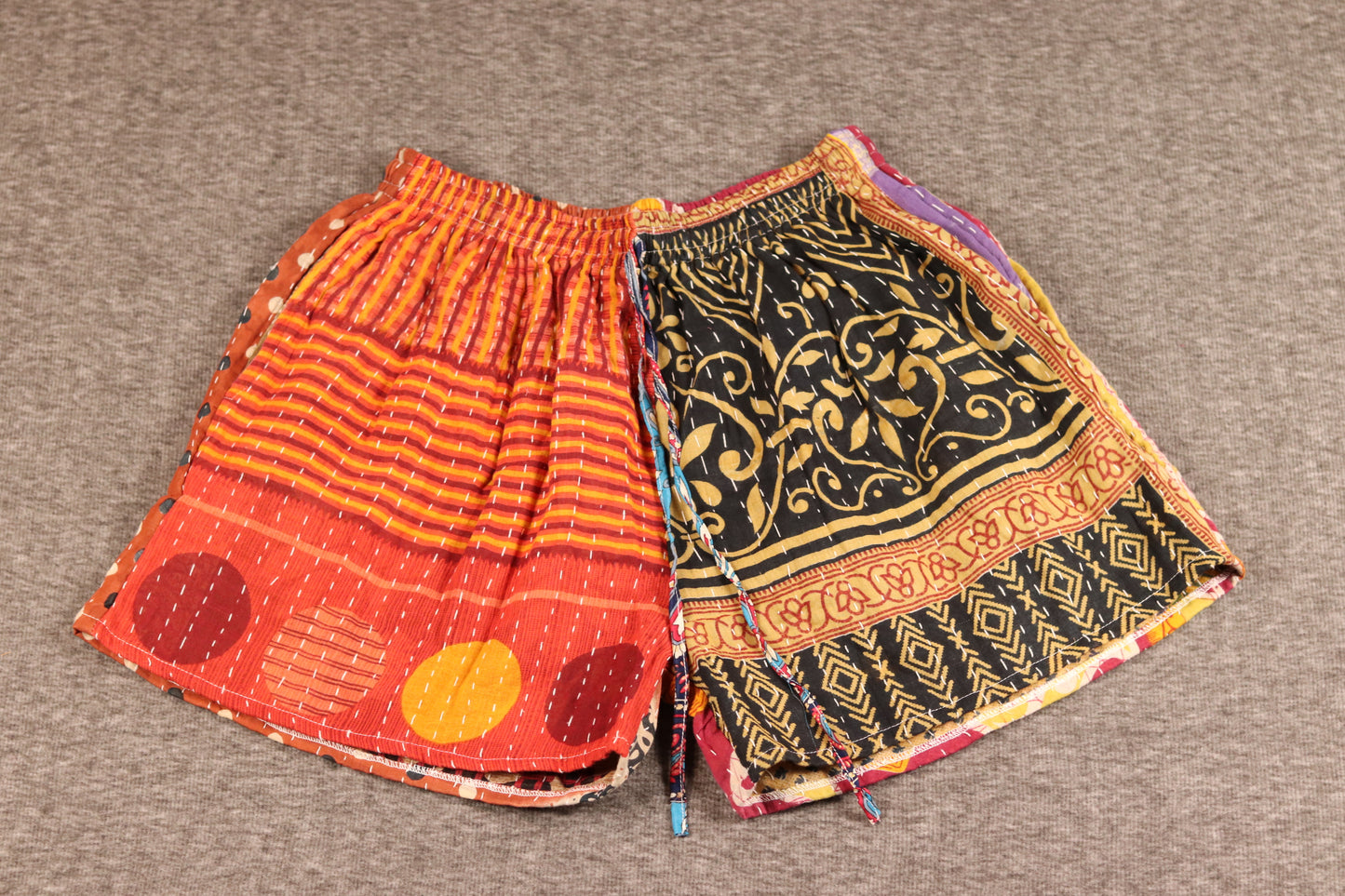 Unisex Kantha shorts in rust, orange, and black cotton with stripe and floral prints, detailed with Kantha stitching and drawstring waist.