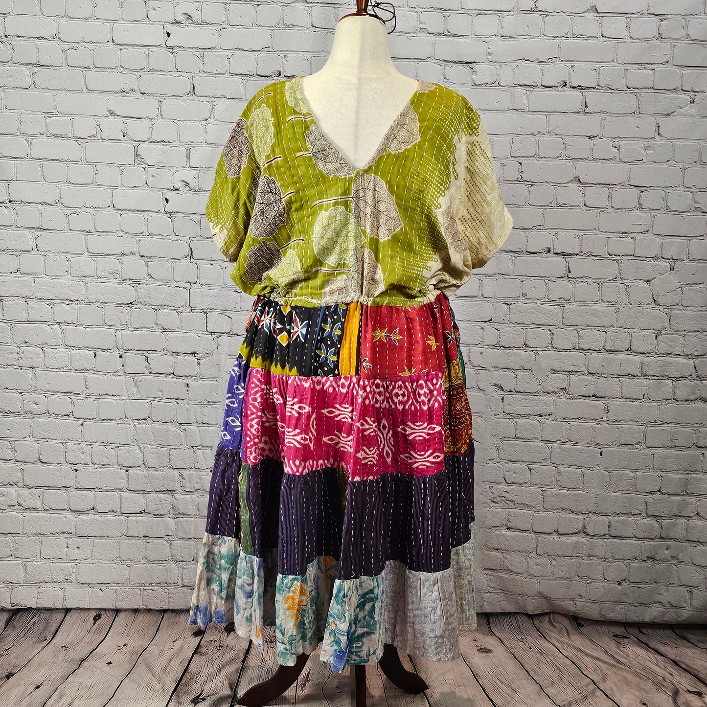 Olive-green leaf-print Twillow Kantha Midi Dress with a multicolor boho patchwork skirt featuring red, navy, blue, gold, and pastel panels with Kantha stitching.