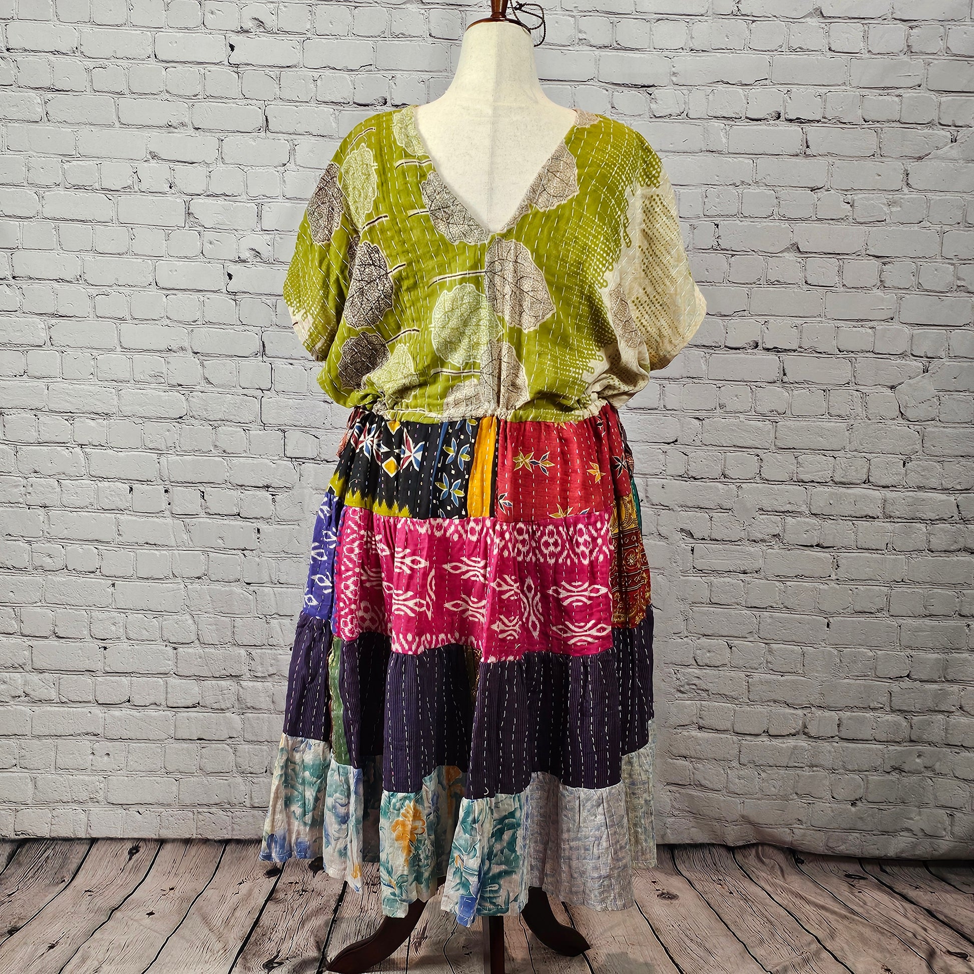 Olive-green leaf-print Twillow Kantha Midi Dress with a multicolor boho patchwork skirt featuring red, navy, blue, gold, and pastel panels with Kantha stitching.