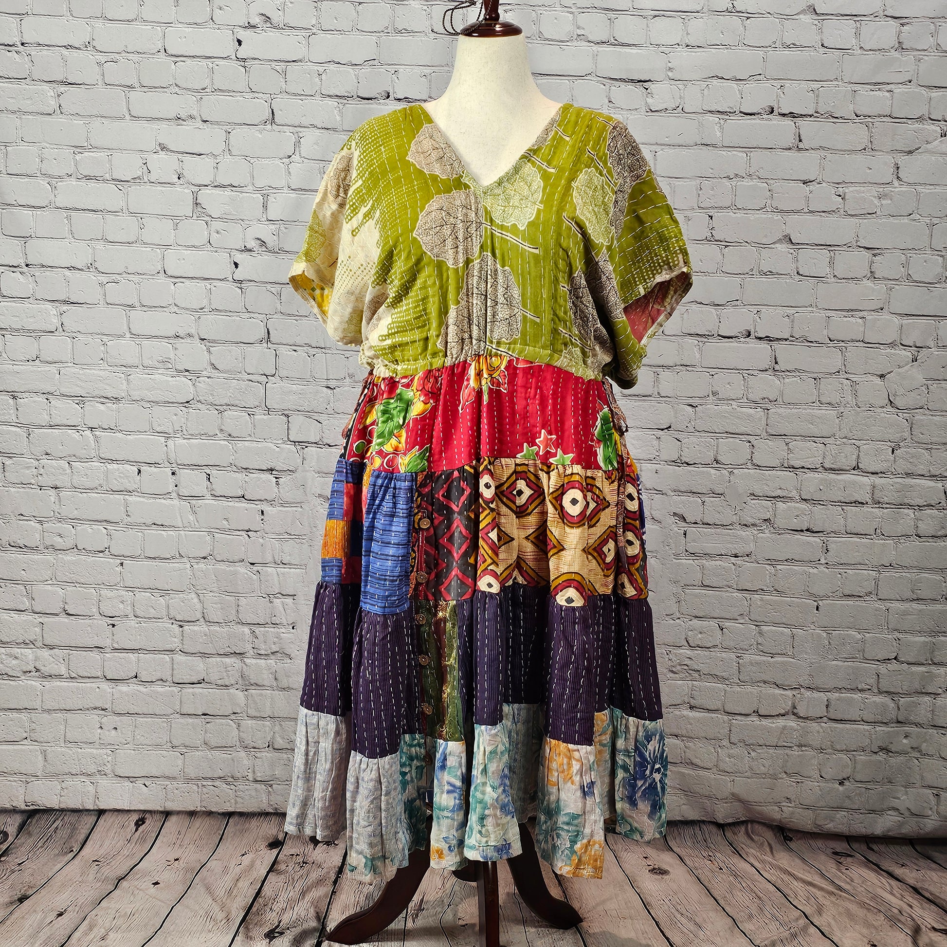Olive-green leaf-print Twillow Kantha Midi Dress with a multicolor boho patchwork skirt featuring red, navy, blue, gold, and pastel panels with Kantha stitching.