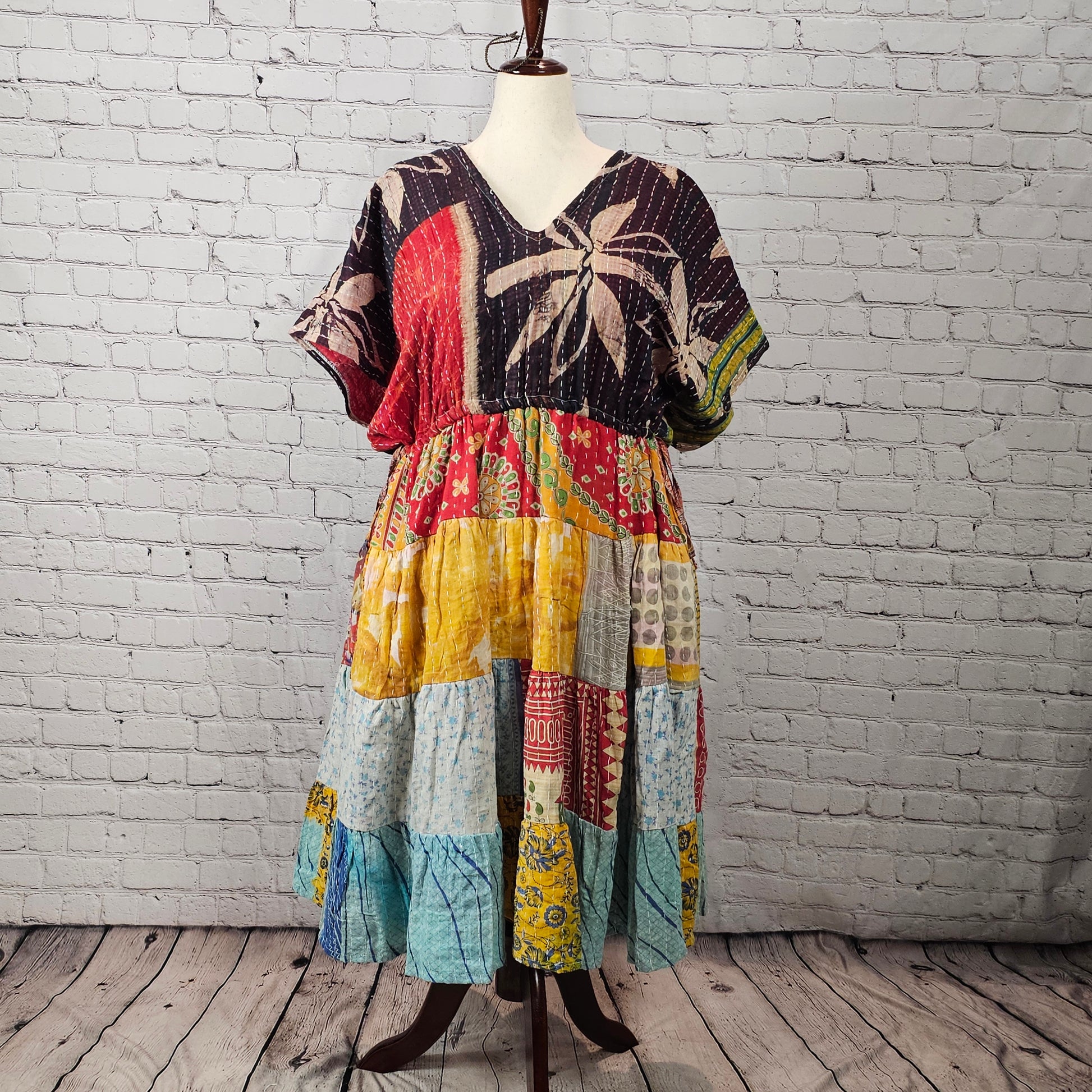 Black palm-print Twillow Kantha Midi Dress with a colorful boho patchwork skirt in yellow, blue, aqua, red, and multicolor panels featuring Kantha stitching.