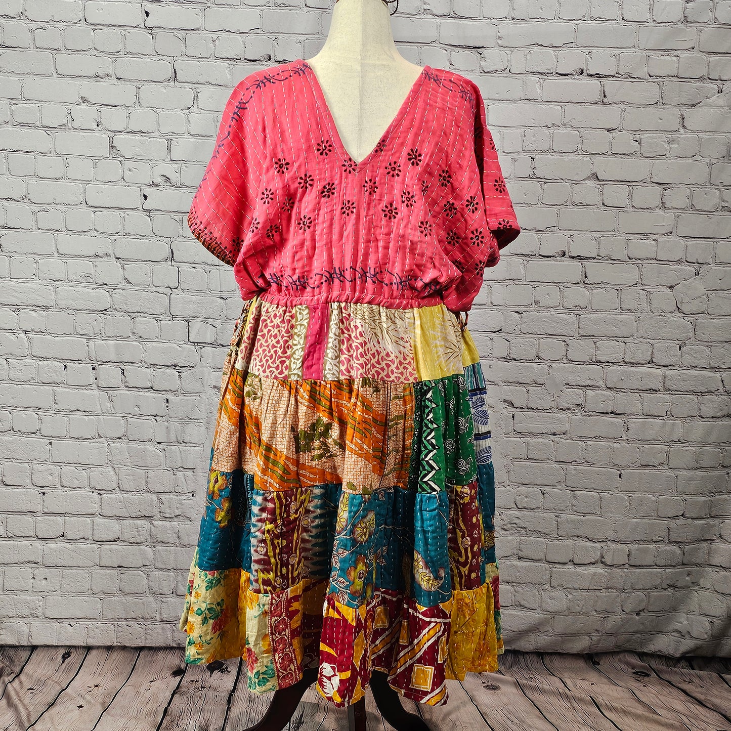 Berry pink Twillow Kantha Midi Dress with teal, maroon, mustard, and geometric patchwork tiers and visible Kantha stitching.