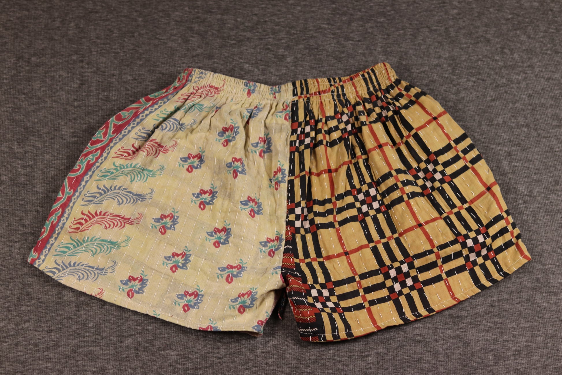 Unisex Kantha shorts with tan, magenta, and golden cotton panels featuring paisley and geometric prints, detailed with Kantha stitching and a drawstring waist.