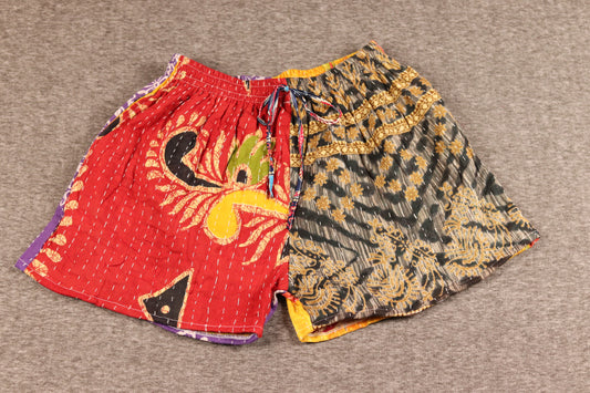 Unisex Kantha shorts with red and charcoal cotton panels featuring abstract and floral prints, detailed with Kantha stitching and a drawstring waist.