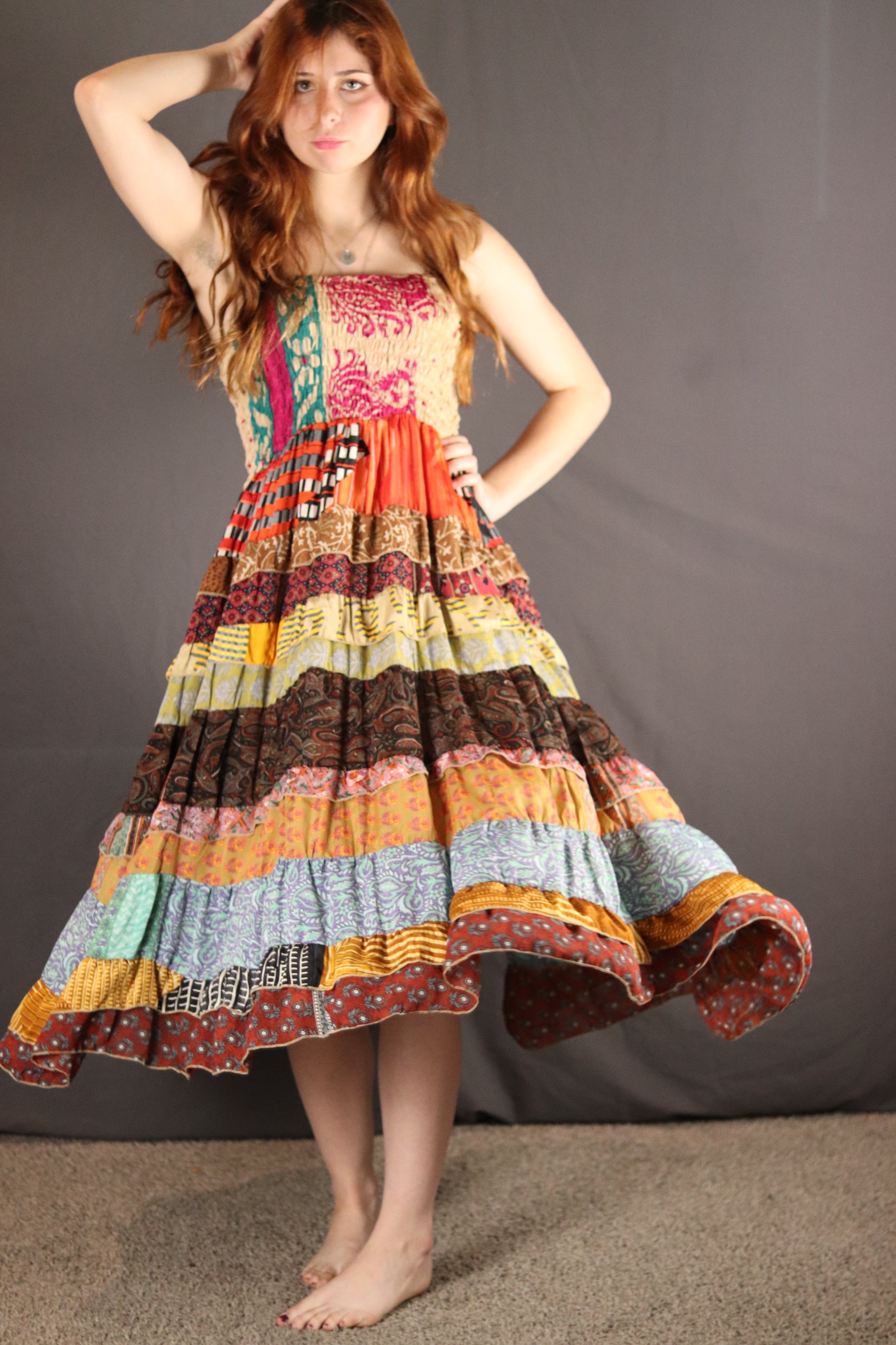 Woman wearing a colorful, patterned dress against a gray background
