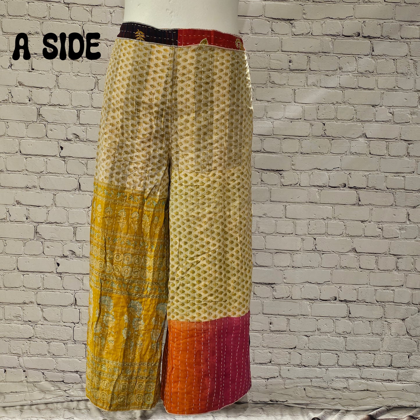Front view of Ronin Kantha unisex wrap pants, made from recycled sari fabric in boho patchwork design.
