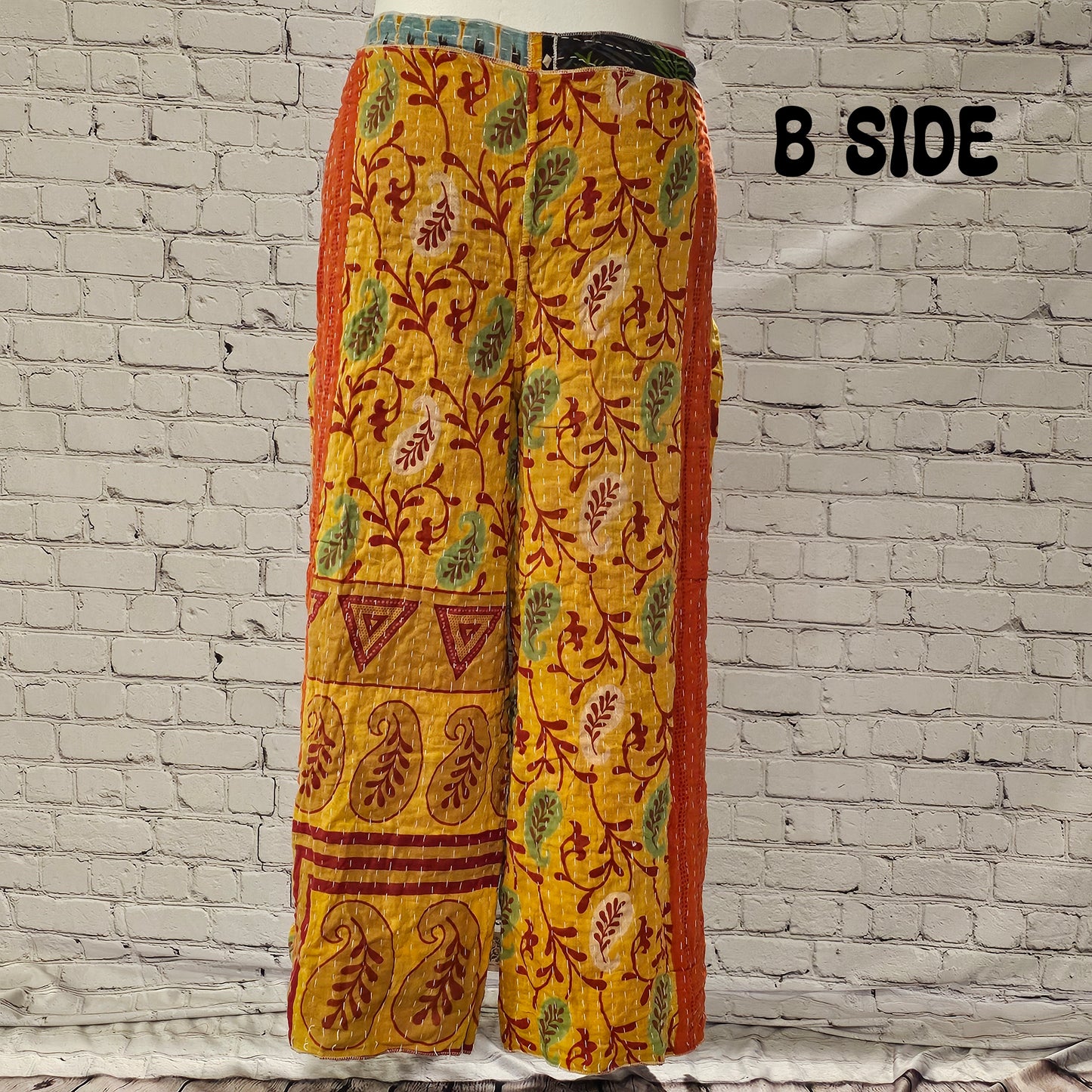 Front view of Ronin Kantha unisex wrap pants, made from recycled sari fabric in boho patchwork design.