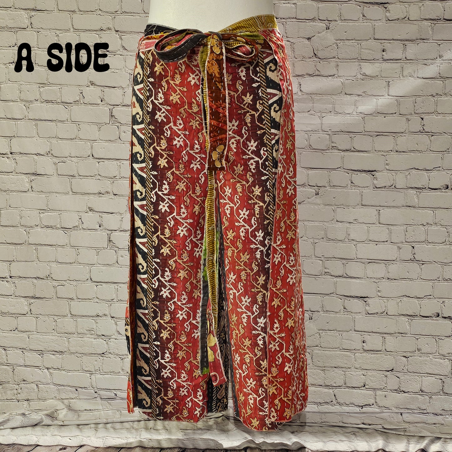Front view of Ronin Kantha unisex wrap pants, made from recycled sari fabric in boho patchwork design.