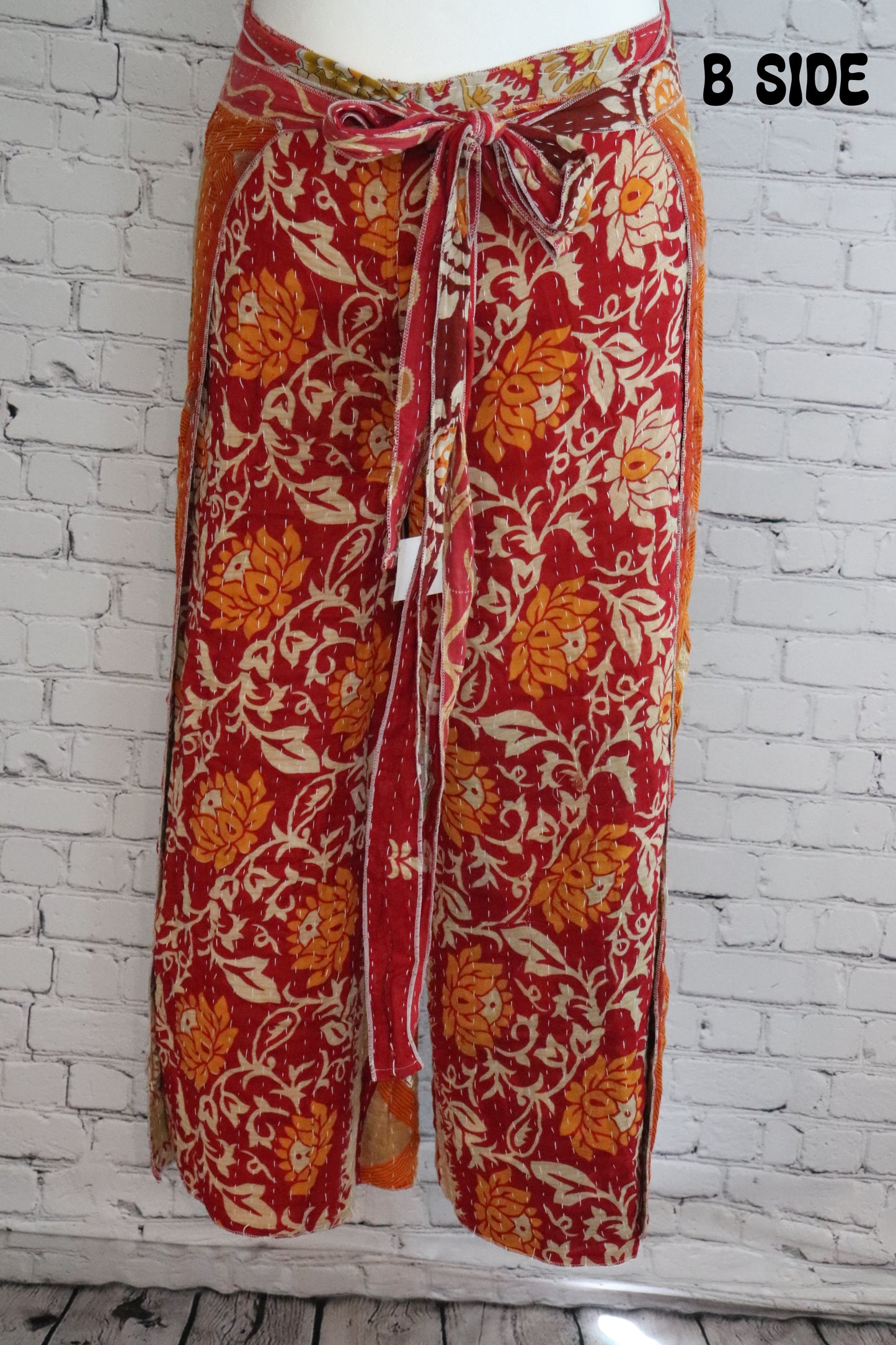 Front view of Ronin Kantha unisex wrap pants, made from recycled sari fabric in boho patchwork design.