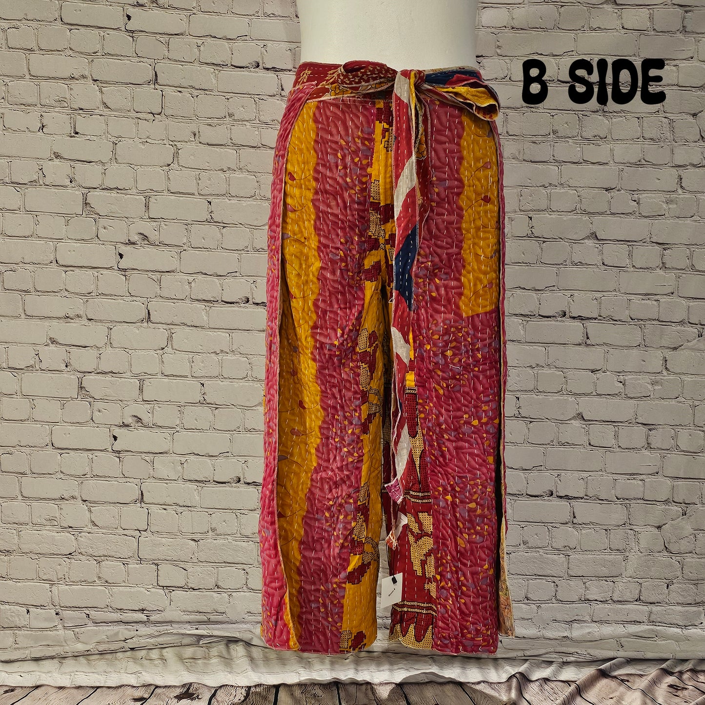 Front view of Ronin Kantha unisex wrap pants, made from recycled sari fabric in boho patchwork design.